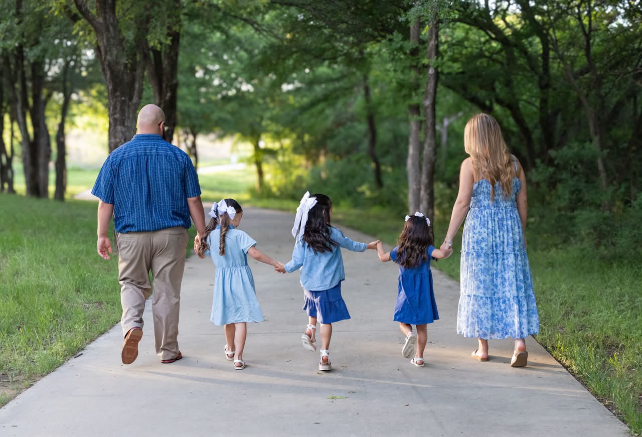Family walking together on a tree-lined path